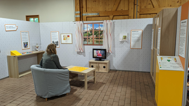 Blick in den Ausstellungsraum &amp;quot;Wohnzimmer&amp;quot;. Auf einem Bildschirm k&ouml;nnen ausgew&auml;hlte Sportgeschichten angeschaut werden. Foto: Anne Kraft